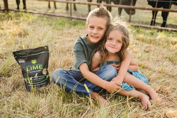An young boy and girl sitting next to a bag of First Saturday Lime.
