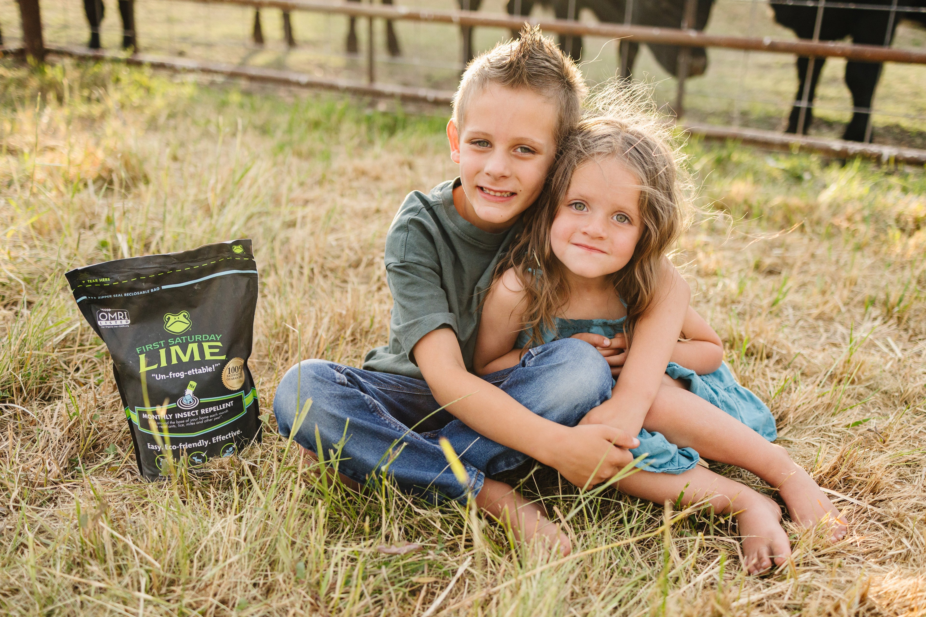 An young boy and girl sitting next to a bag of First Saturday Lime.