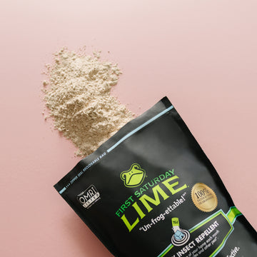 A bag of First Saturday Lime with the powder spilling out on a pink background.