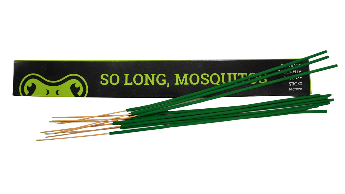 Green First Saturday Lime mosquito repellent incense sticks, arranged in front of their black packaging box featuring a green frog graphic and the text 'SO LONG, MOSQUITOS'.