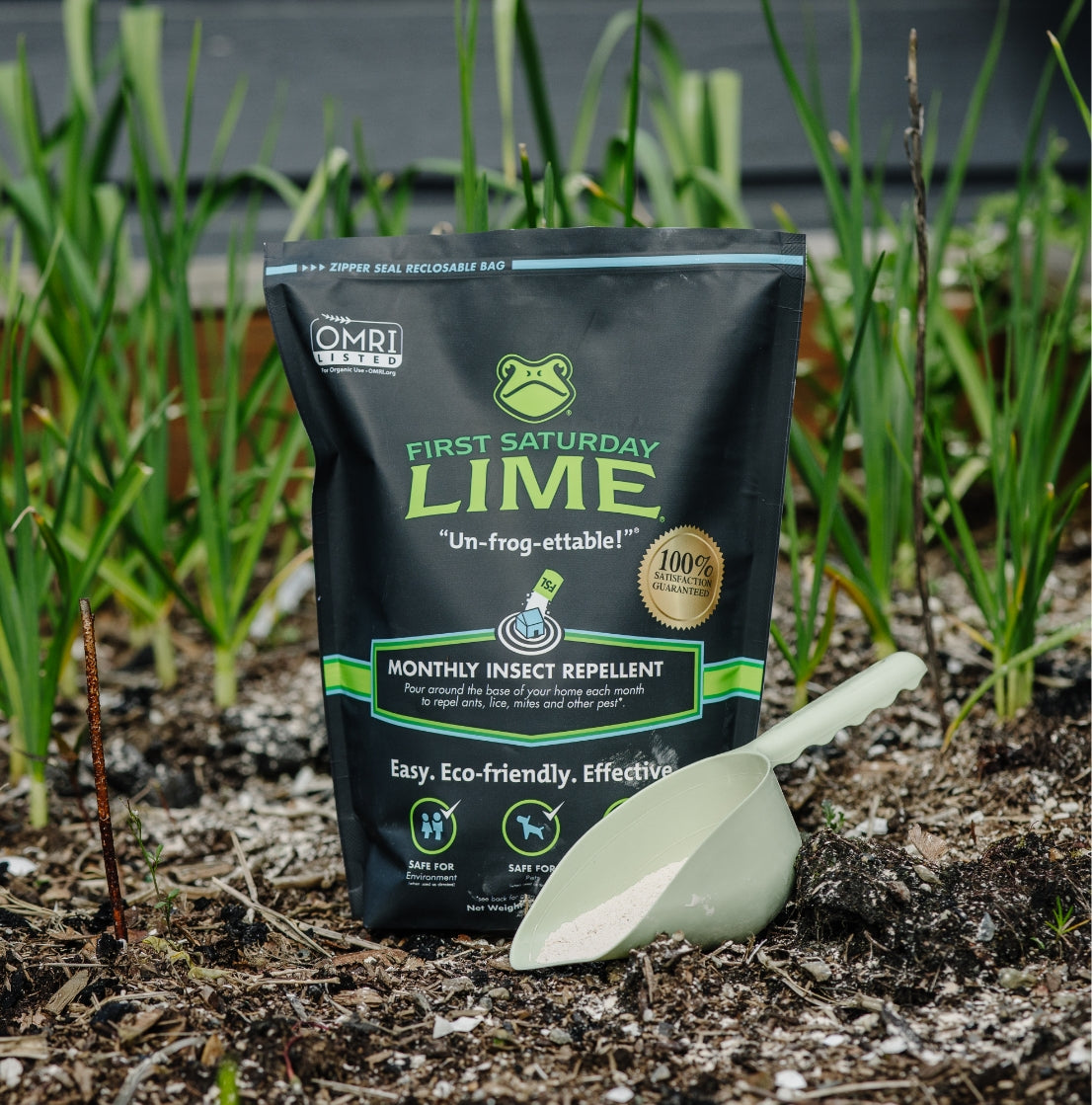 Bag of 'First Saturday Lime' insect repellent with a green scoop on soil.