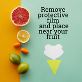 A green gnat trap on a colorful back ground with fruit and text that reads "Remove protective film and place near your fruit."